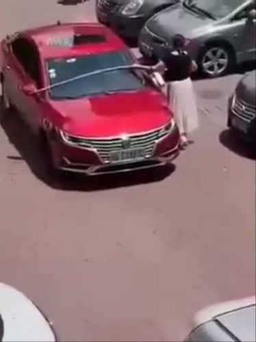 女性運転手が駐車場に駐める際にメジャーで車幅を測る珍行動